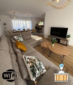 a living room with a couch and a table at Ker Phan Cozy urban cottage with hot tub in Saint-Aubin-du-Cormier