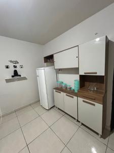 eine Küche mit weißen Schränken und einem Kühlschrank in der Unterkunft Flat Girassol 02 próximo a Graciosa e UFT in Palmas