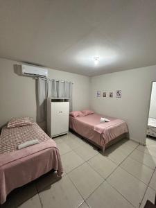 2 Betten in einem Zimmer mit rosa Bettwäsche in der Unterkunft Flat Girassol 02 próximo a Graciosa e UFT in Palmas