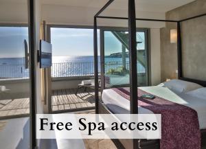 a room with a bed and a balcony with the words free spa access at Royal Antibes - Luxury Hotel, Résidence, Beach & Spa in Antibes