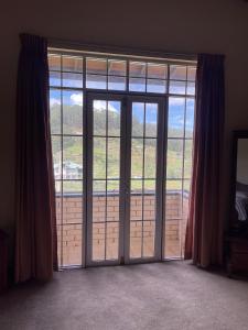 an open sliding glass door with a view at The Vatican in Nuwara Eliya