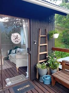 eine Tür zu einem winzigen Haus mit einer Veranda in der Unterkunft Griffin's Nest Cottage in Mbabane