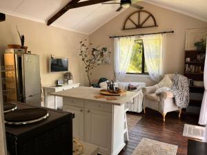 eine Küche mit einer Kücheninsel und ein Wohnzimmer in der Unterkunft Griffin's Nest Cottage in Mbabane