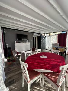 a dining room with a red table and chairs at Rosso Relativo in Acilia