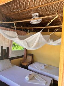 two beds in a room with a mosquito net at Kwa Simba Tanzania in Pangani