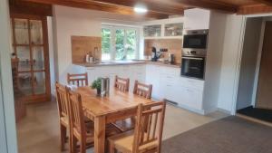 a kitchen with a wooden table and some chairs at Penzion V Kopci in Kořenov
