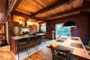 a kitchen and dining room with a table and chairs at Superbe maison à 1 kilomètre de la Marina in LʼAnse-Saint-Jean