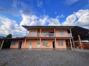 a large building with a balcony on top of it at Finca Campestre El Pindal in Guamal