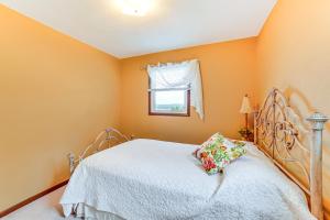 a bedroom with orange walls and a bed and a window at Watch the Sunrise at this Quaint Lake-View Cottage in Peoria