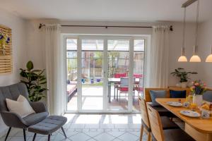 a dining room and living room with sliding glass doors at AlzBlüte in Truchtlaching