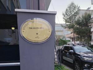 eine Uhr an der Seite eines Gebäudes mit einem Auto in der Unterkunft Brand Otel in Didim