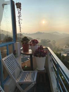 a chair on a balcony with a table and flowers at Shanti Homestay in Xuan An +11 photos