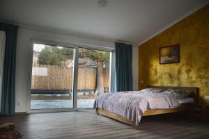 Un dormitorio con una cama y una gran puerta corrediza de vidrio. en Bungalov Vlnka, en Vlachy
