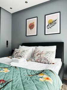 トルンにあるApartament Chełmionkaのベッドルーム1室(壁に2枚の写真が飾られたベッド1台付) +14枚の写真