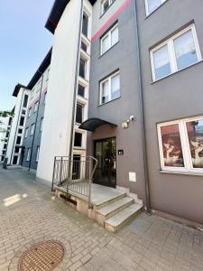 トルンにあるApartament Chełmionkaの玄関に続く階段のある建物