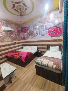范兰德凡K D Dham Near Prem Mandir Iskcon temple Vrindavan的一间设有两张床和鲜花的墙壁的房间