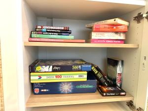 a stack of books sitting on a book shelf at HeideHygge 4 in Schneverdingen