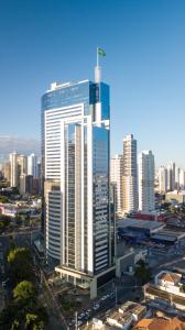 a tall skyscraper in a city with many buildings at Roomo Transamerica Goiânia Orion in Goiânia
