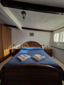 Un dormitorio con una cama azul con dos toallas encima. en Balcone sul Vesuvio, en Vico Equense