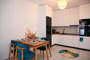 a kitchen with a wooden table and blue chairs at Maison de jolie in Golem