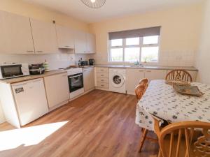 eine Küche mit einem Tisch und einem Tisch sowie ein Esszimmer in der Unterkunft Hill House in Ballymoney