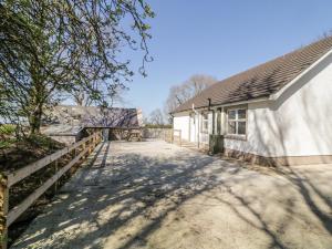 ein Haus mit einem Zaun neben einem Gebäude in der Unterkunft Hill House in Ballymoney