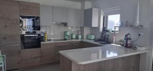 a kitchen with wooden cabinets and a white counter top at almoaj ,juman 2 marina view,level3 in Muscat