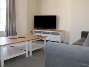 Televiisor ja/või meelelahutuskeskus majutusasutuses The Newborough sleeps 8 Apartments