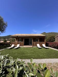 a house with lounge chairs in the yard at Les collines de lava in Appietto