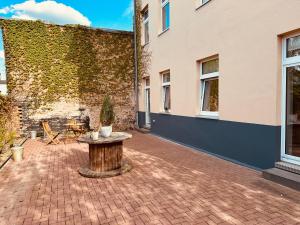 a brick courtyard with a table and a building at Moderne Wohnung in Eberswalde in Eberswalde