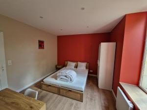a small room with a bed and a refrigerator at Appartement Le 94 in Lurcy-Lévis