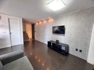a living room with a flat screen tv on a wall at Apto de Luxo Loft Duplex em área nobre na Doca in Belém