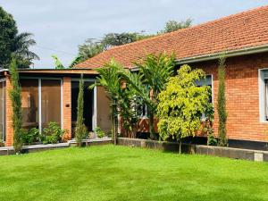 a house with a green lawn in front of it at A Modern Fully Furnished 5Bedroom House In Rubaga Kampala For Rent in Kampala