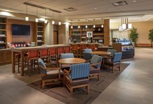 a restaurant with tables and chairs and a bar at Hyatt Place Lincoln/Downtown-Haymarket in Lincoln