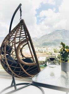 a hanging basket chair on a table with a glass of wine at Comfy Vista Apartment in Kalamata