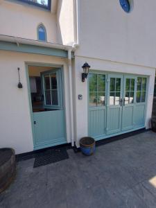 a garage with green doors on a house at Little Brook in Exmouth