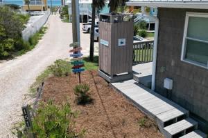 a garden next to a house with a pole at North Cape- Behing Trading Post - Pet Friendly in Cape San Blas