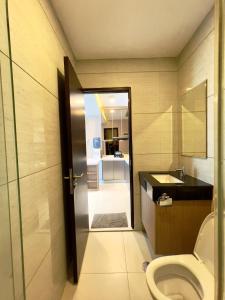 ein Badezimmer mit Toilette und Waschbecken in der Unterkunft apartemen brooklyn alsut Studio bergaya modern,pusatkota,cozy,pool,gym,wifi in Dongkal Dua