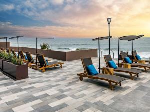 a row of chairs sitting on a patio next to the ocean at Beachfront Condo with Balcony amazing view in Tijuana