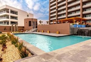 a swimming pool in front of a building at Beachfront Condo with Balcony amazing view in Tijuana