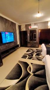 a hotel room with a large living room with a tv at Hotel Oasis in Islamabad