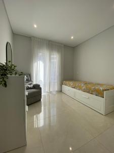 un ampio soggiorno con un letto e un divano di Iate Residence a Portimão