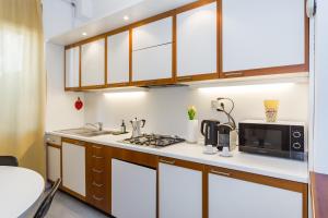 a kitchen with a sink and a microwave at Villetta con balcone - vicino Linate e stazione in Pioltello