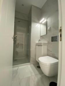 un bagno bianco con wc e doccia di Iate Residence a Portimão