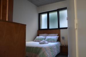 a bedroom with a bed and two windows at Super studio in Saint-Denis