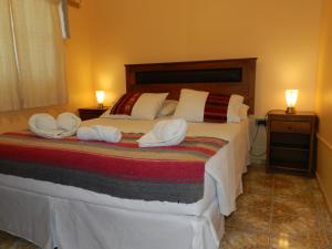 a bedroom with a bed with two white pillows at Hostal Illari in San Pedro de Atacama