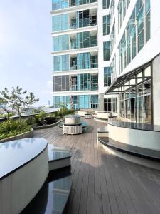 Blick auf ein Gebäude mit einer Terrasse davor in der Unterkunft apartemen brooklyn alsut Studio bergaya modern,pusatkota,cozy,pool,gym,wifi in Dongkal Dua