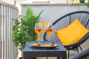 two glasses of wine and a plate of fruit on a table at Villetta con balcone - vicino Linate e stazione in Pioltello +18 photos