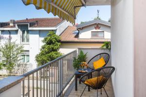 a balcony with two chairs and a table at Villetta con balcone - vicino Linate e stazione in Pioltello