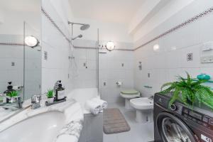 a bathroom with a tub and a toilet and a washing machine at Villetta con balcone - vicino Linate e stazione in Pioltello